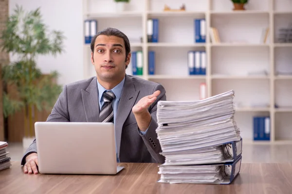 Jovem funcionário masculino infeliz com excesso de trabalho no escritório — Fotografia de Stock