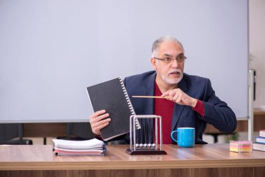 Sınıfta oturan eski bir fizikçi öğretmen.