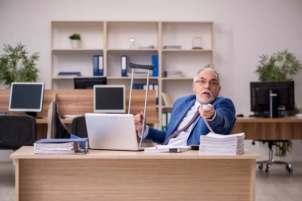 Gammal affärsman anställd efter olycka arbetar på kontoret — Stockfoto