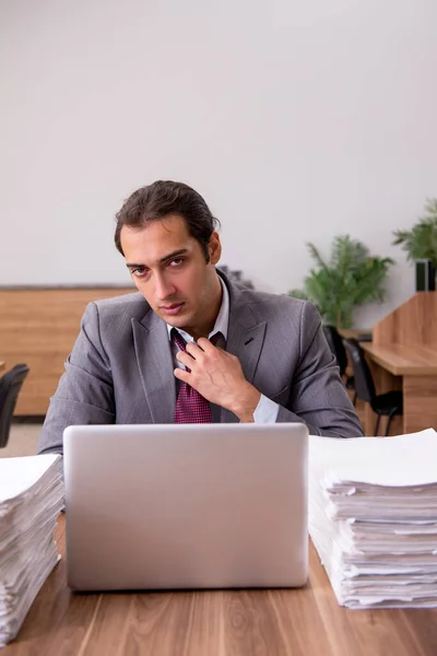 Jovem funcionário masculino infeliz com excesso de trabalho no escritório — Fotografia de Stock