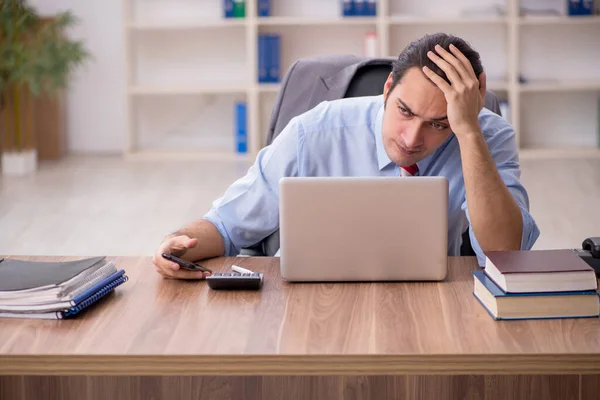 Jovem trabalhador masculino sentado no local de trabalho — Fotografia de Stock