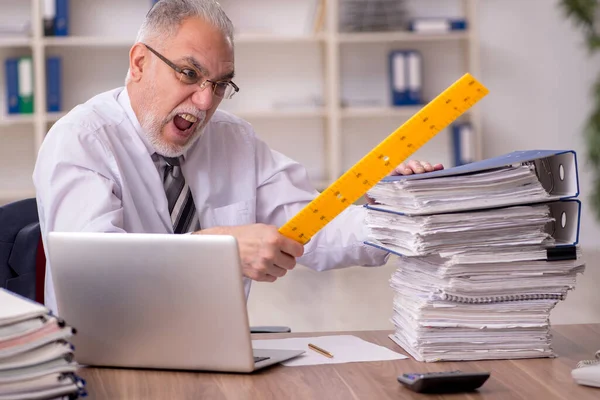Hombre anciano empleado infeliz con el trabajo excesivo en la oficina —  Fotos de Stock