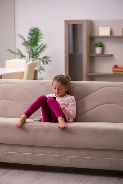 Liten flicka som håller smartphone väntar på föräldrar hemma — Stockfoto
