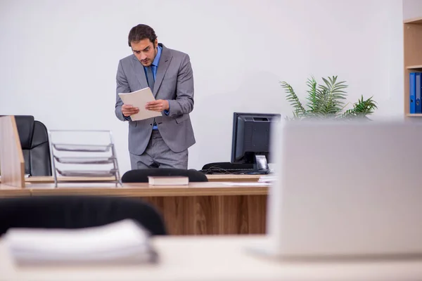 Young male employee in industrial espionage concept