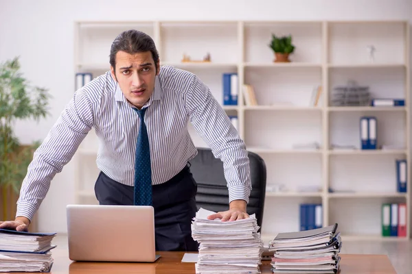 Jovem funcionário masculino infeliz com excesso de trabalho no escritório — Fotografia de Stock