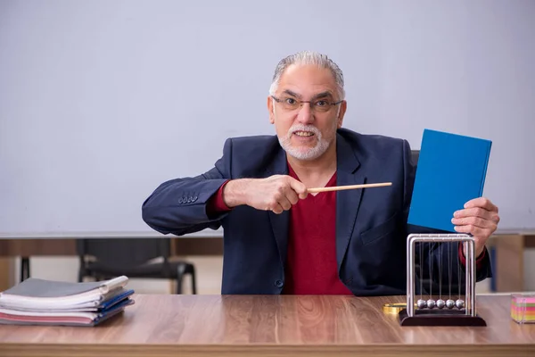 Antigo professor físico sentado na sala de aula — Fotografia de Stock