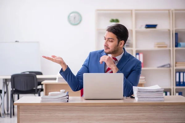 Jovem empregado atraente que trabalha no escritório — Fotografia de Stock