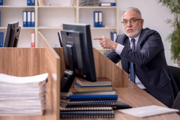 Velho empregador masculino e muito trabalho no escritório — Fotografia de Stock