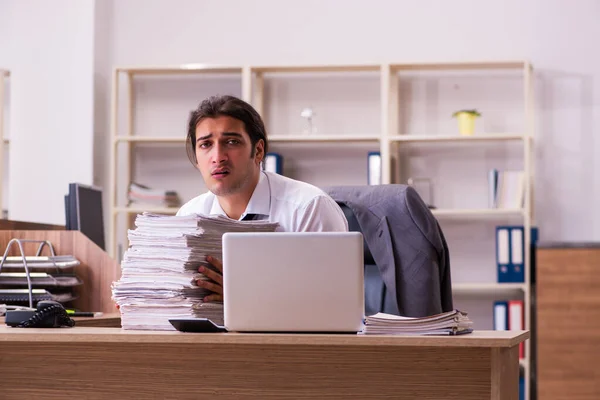 Jovem funcionário masculino infeliz com excesso de trabalho no escritório — Fotografia de Stock