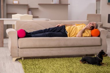 Evde köpeği olan yaşlı bir adam.