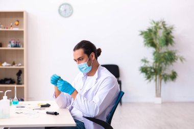 Salgın sırasında laboratuvarda çalışan genç bir kimyager.