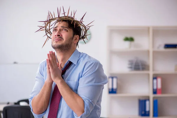 Mladý muž zaměstnanec nosí pichlavý věnec na hlavě — Stock fotografie