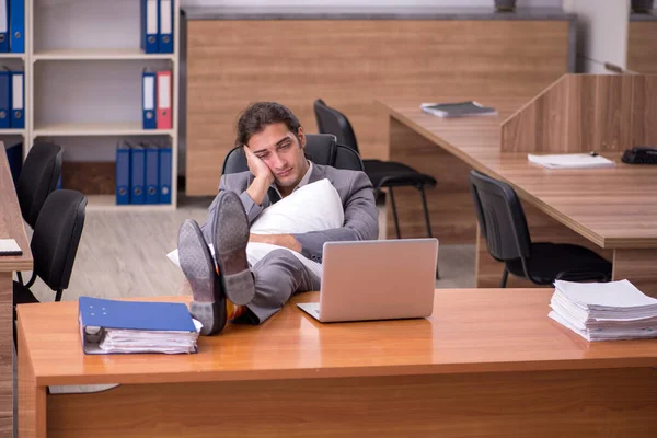 Joven empleado masculino durmiendo en el lugar de trabajo — Foto de Stock