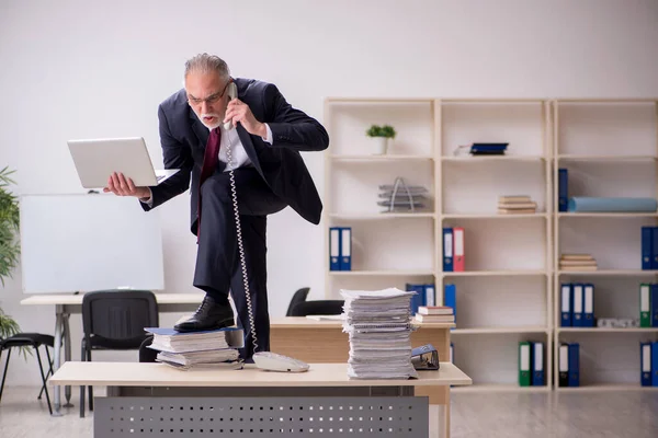 高齢男性従業員と職場で多すぎる仕事 — ストック写真