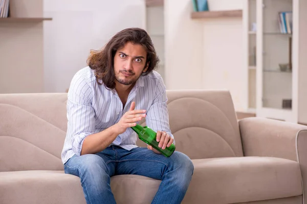 Giovane che beve alcol a casa — Foto Stock