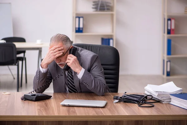 Employé masculin âgé souffrant sur le lieu de travail — Photo