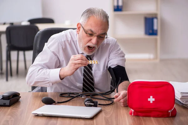 Ältere männliche Mitarbeiter leiden am Arbeitsplatz — Stockfoto