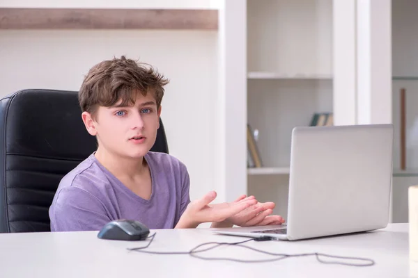 Schooljongen speelt computerspelletjes thuis — Stockfoto