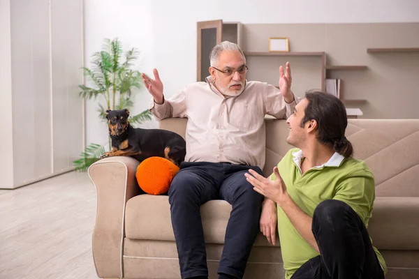 Dois homens com cão em casa — Fotografia de Stock