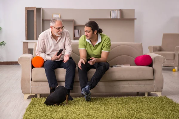 Dois homens com cão em casa — Fotografia de Stock