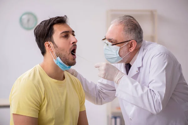 Young male patient visiting old male doctor otorhinolaryngologis — Stock Photo, Image