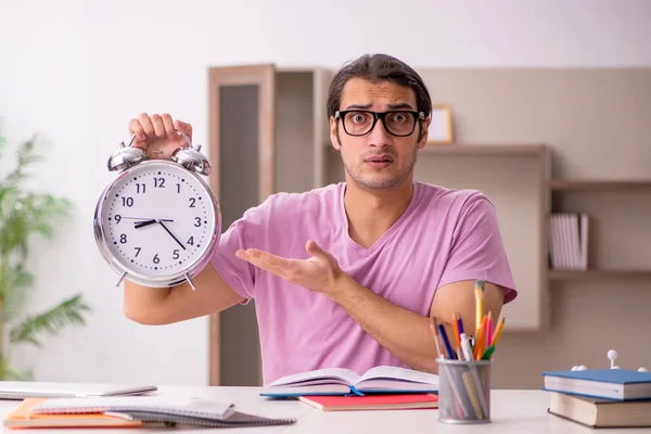 Jonge mannelijke student in time management concept — Stockfoto