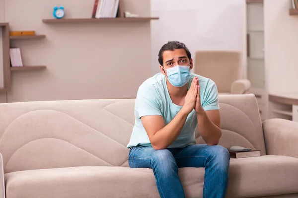 Ung mann sitter hjemme under pandemien – stockfoto