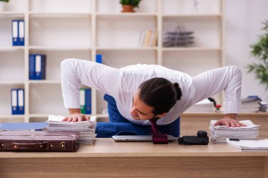 Mola sırasında spor yapan genç erkek çalışanlar.