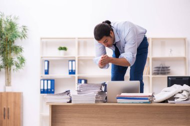 Genç erkek çalışan işyerinde terliyor