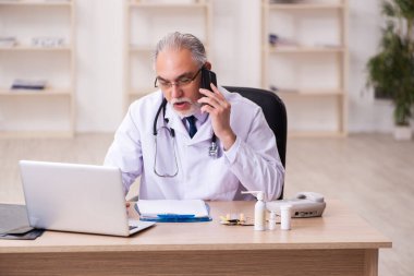 Klinikte çalışan deneyimli bir erkek doktor.