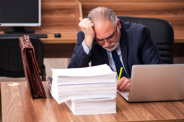 Velho empregado masculino e muito trabalho no escritório — Fotografia de Stock