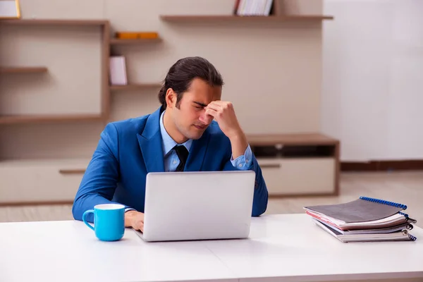 Ung manlig anställd som arbetar hemifrån under en pandemi — Stockfoto