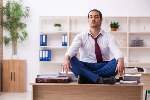 Junge männliche Angestellte macht in der Pause Yoga-Übungen — Stockfoto