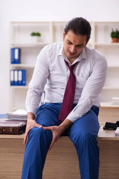 Joven empleado masculino sintiéndose mal en la oficina — Foto de Stock