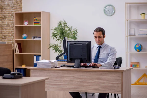Jovem funcionário do sexo masculino sentado no escritório — Fotografia de Stock