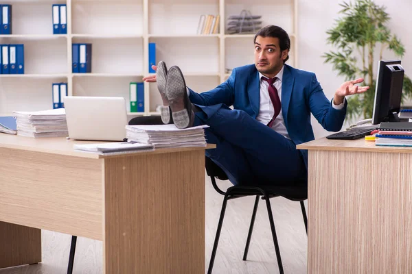 Young male employee in multitasking concept — Stock Photo, Image