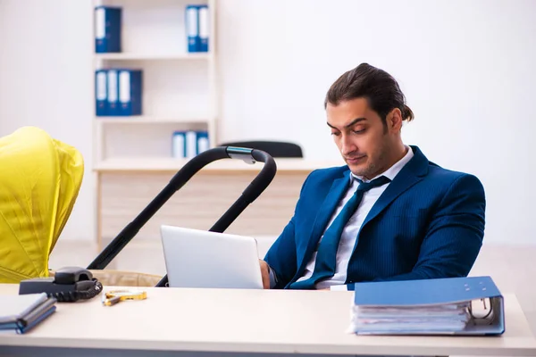 Junge männliche Angestellte kümmert sich am Arbeitsplatz um Kind — Stockfoto