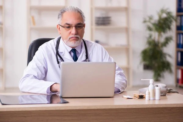 Ervaren mannelijke arts werkzaam in de kliniek — Stockfoto