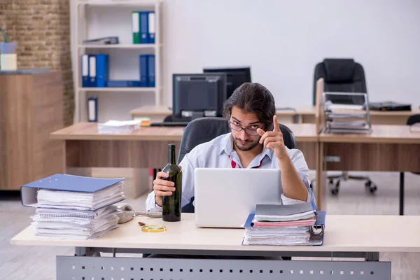 Молодой работник, пьющий алкоголь в офисе — стоковое фото