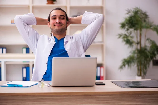 Ung manlig läkare som arbetar på kliniken — Stockfoto