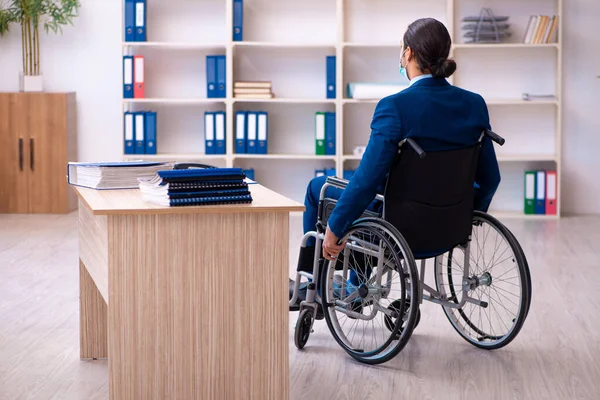 Young disabled employee during pandemic at workplace — Stock Photo, Image