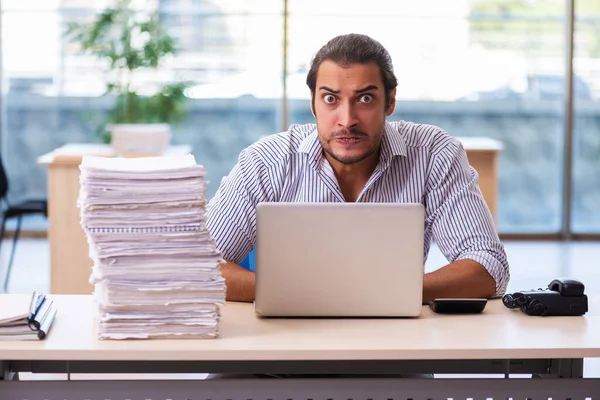 Joven empleado masculino descontento con el trabajo excesivo en la oficina —  Fotos de Stock