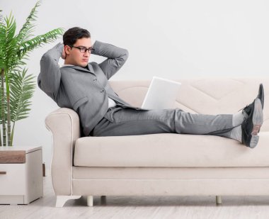 Genç işadamı kanepede yatıyor.