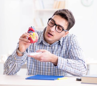 Tıp öğrencisi kalbi söküyor.