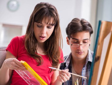 Stüdyoda resim sınıfında sanatçı koçluğu yapan bir öğrenci.