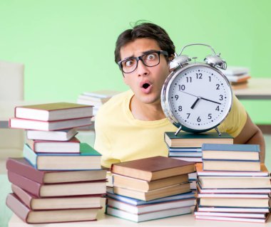 Sınavdan önce okumak için çok fazla kitabı olan öğrenci
