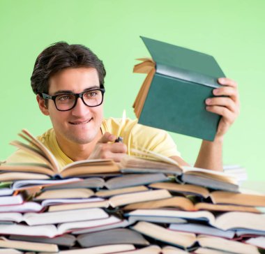 Sınavdan önce okumak için çok fazla kitabı olan öğrenci