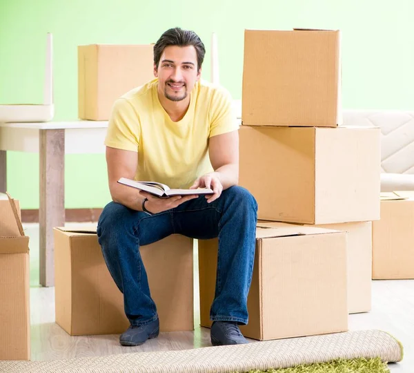 Молодий красивий чоловік переїжджає в новий будинок з коробками — стокове фото