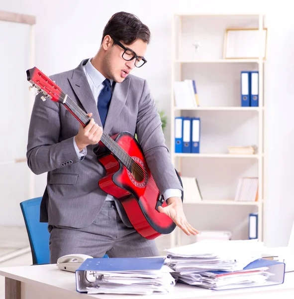 Jeune homme d'affaires beau jouant de la guitare dans le bureau — Photo