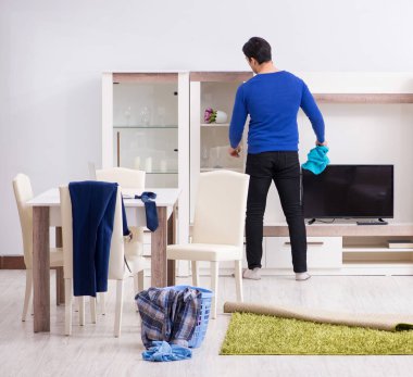 Genç adam çamaşırhane için kirli çamaşır topluyor.